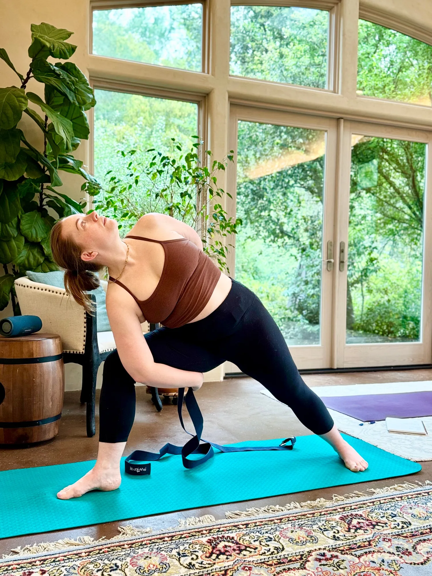 Sara practicing warrior pose with a yoga strap